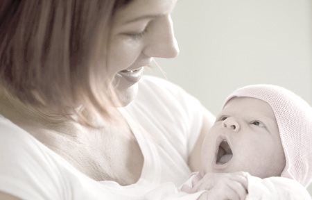 Woman is holding new born in her arms.