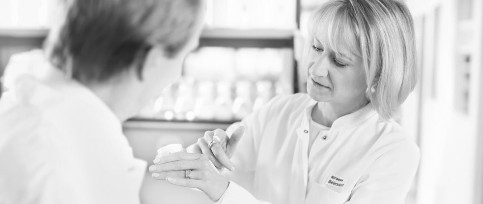 Female scientist is applying cream on the back of her hand