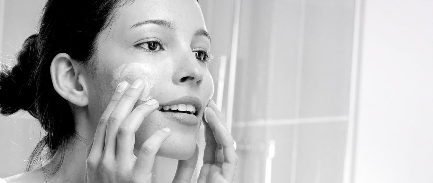 Woman appliying cream on her face