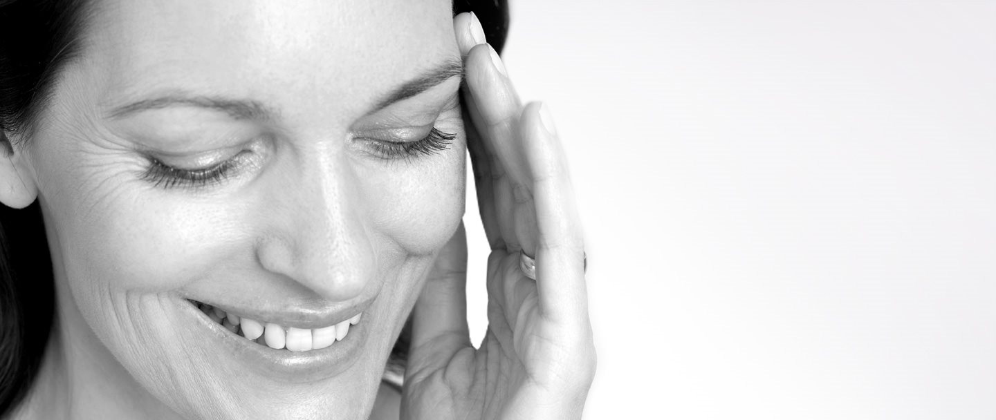 Woman touching her face with her left hand.