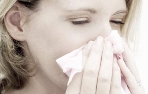Woman blows her nose.