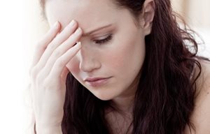 Woman in a thinking pose - with one hand on her forehead.