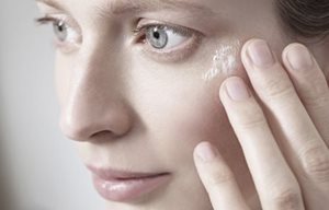 Woman touching her face with hand.